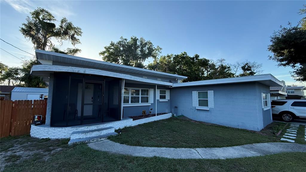 A single-story blue house features a screened-in front porch and a concrete walkway — 811 22ND STREET NW, WINTER HAVEN, FL