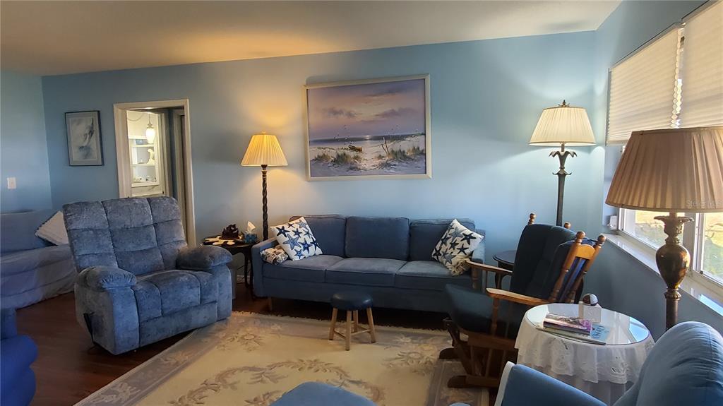A living room features blue walls, a sofa, a recliner, and two floor lamps — 1765 LORALIN DRIVE, ENGLEWOOD, FL
