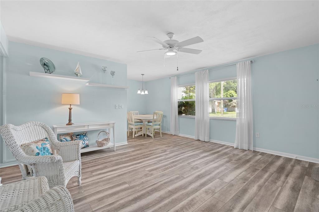 A light blue living and dining area features wood-look flooring and a ceiling fan — 209 NE LINCOLN CIRCLE N UNIT 109, ST PETERSBURG, FL