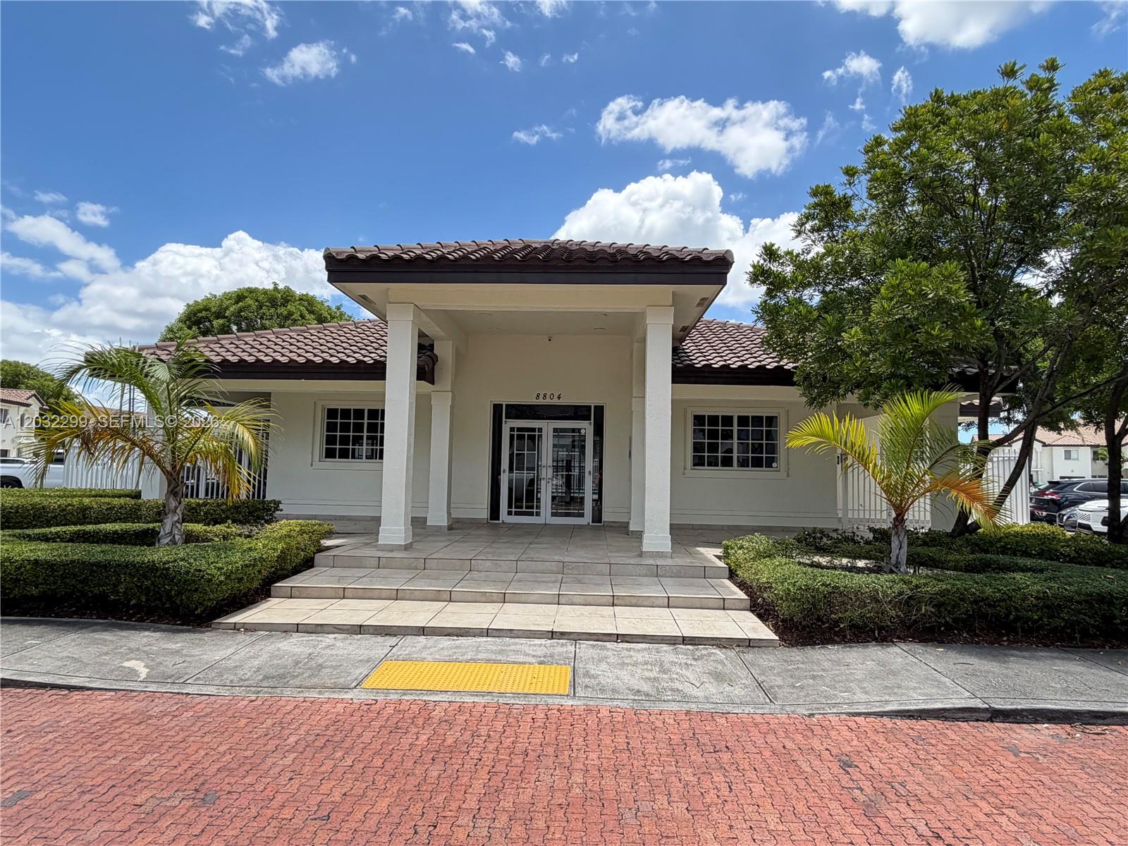 A single-story building with a tiled roof, white columns, and a paved entrance — 8802 NW 109th Ct # 607, Doral FL 33178, DORAL, FL