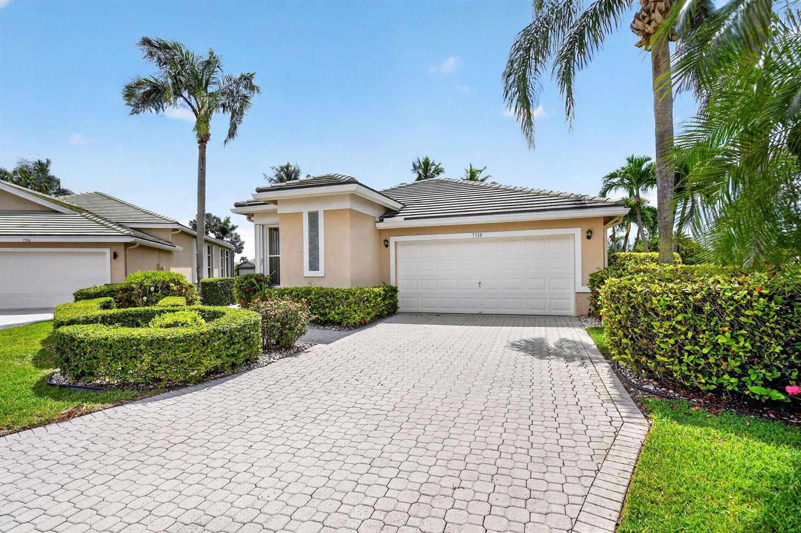 A single-story house with a beige stucco exterior, a tiled roof, and a paved driveway — 7760 Carrington Court, Boynton Beach FL 33472, BOYNTON BEACH, FL