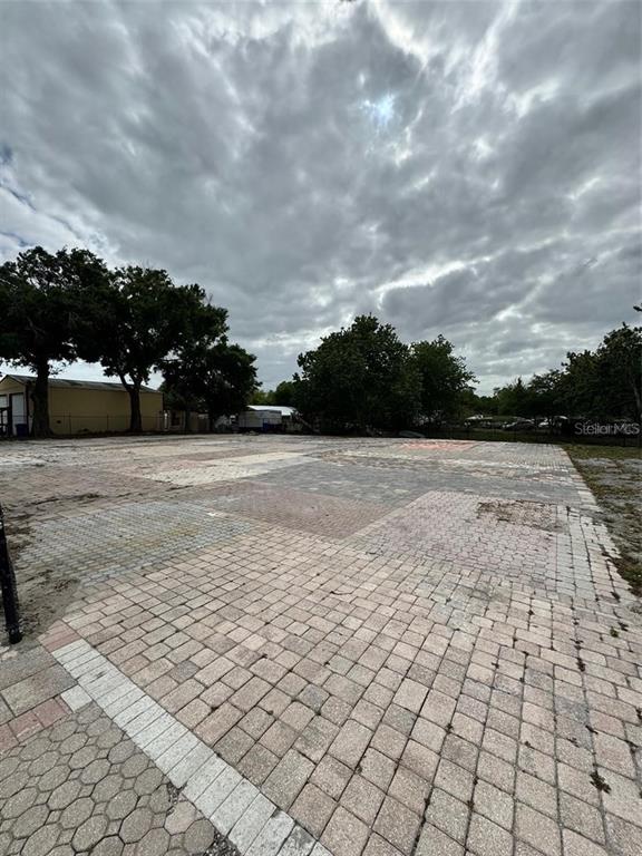 A large, flat outdoor lot paved with various styles of concrete pavers under a cloudy sky — 580 FAIRVILLA ROAD, ORLANDO, FL