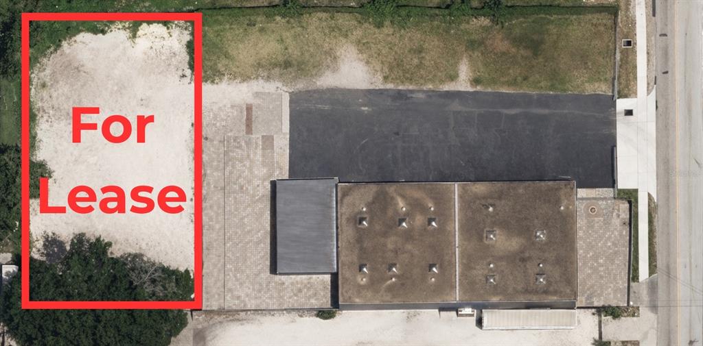 This aerial view shows a commercial building with a paved parking lot and a vacant lot — 580 FAIRVILLA ROAD, ORLANDO, FL