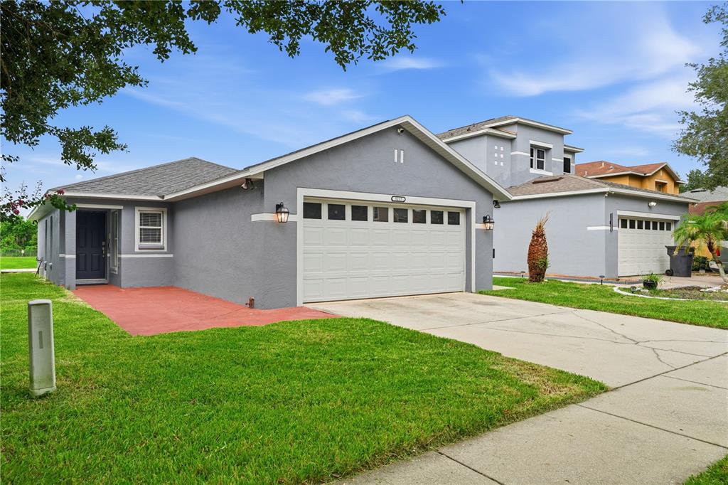 A gray single-story house with a two-car garage and a red concrete walkway — 5217 MANGO FRUIT STREET, SEFFNER, FL