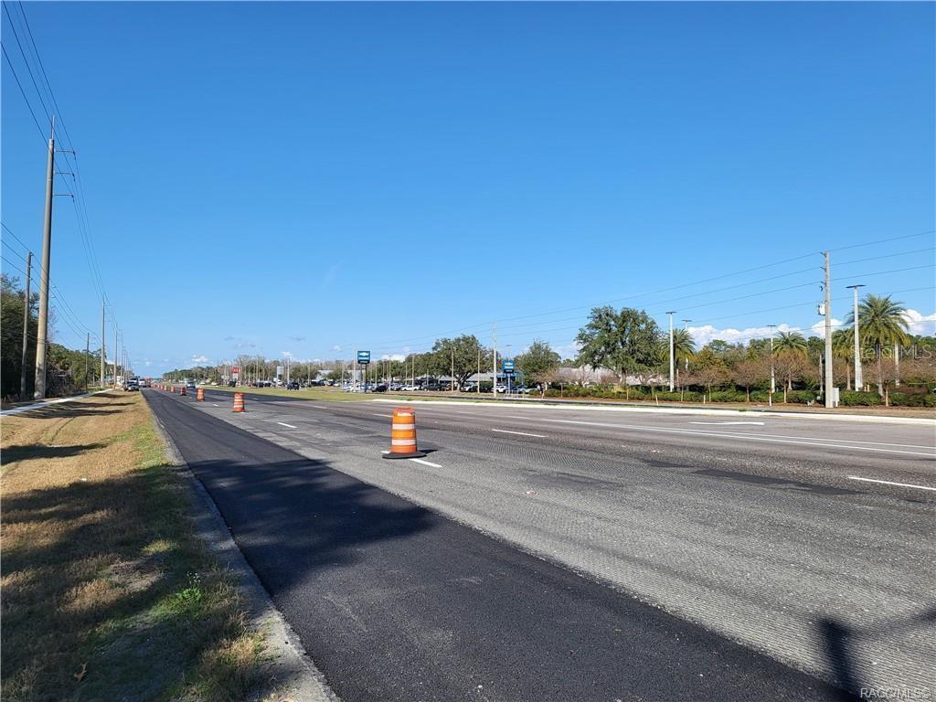 A paved road stretches into the distance with orange traffic cones lining the shoulder — 1224 S SUNCOAST BOULEVARD, HOMOSASSA, FL