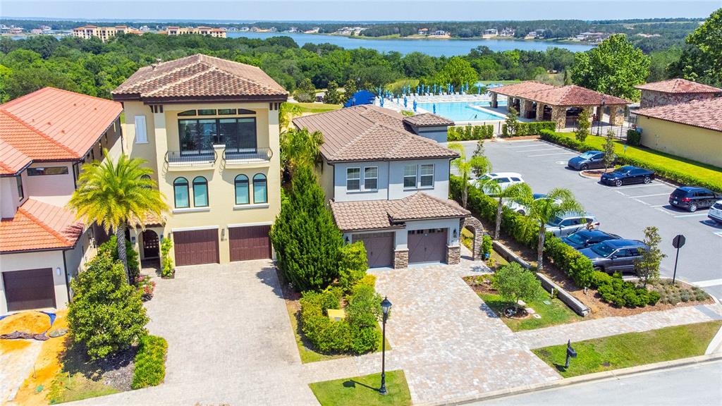 An aerial view shows two adjacent Mediterranean-style houses with tile roofs and paved driveways — 16210 RAVENNA COURT, MONTVERDE, FL