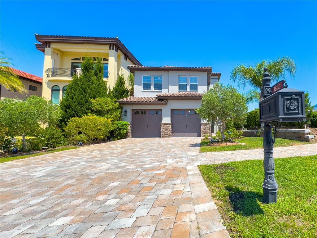 A two-story house with a paved driveway and a decorative mailbox in the foreground — 16210 RAVENNA COURT, MONTVERDE, FL