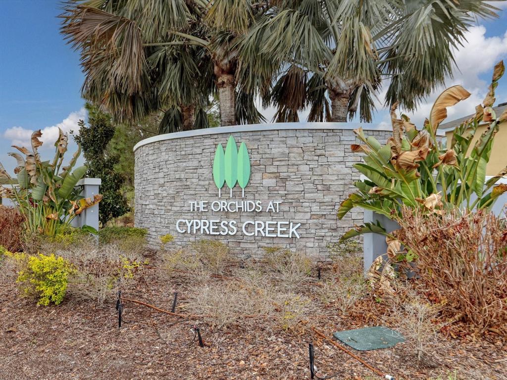 A stone monument sign displays the name The Orchids at Cypress Creek outdoors — 10003 GEESE TRAIL CIRCLE, SUN CITY CENTER, FL