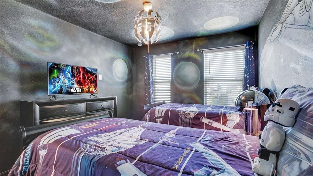 A Star Wars-themed bedroom features two twin beds, a television, and space-themed wall murals — 2147 COOPER BELL PLACE, KISSIMMEE, FL