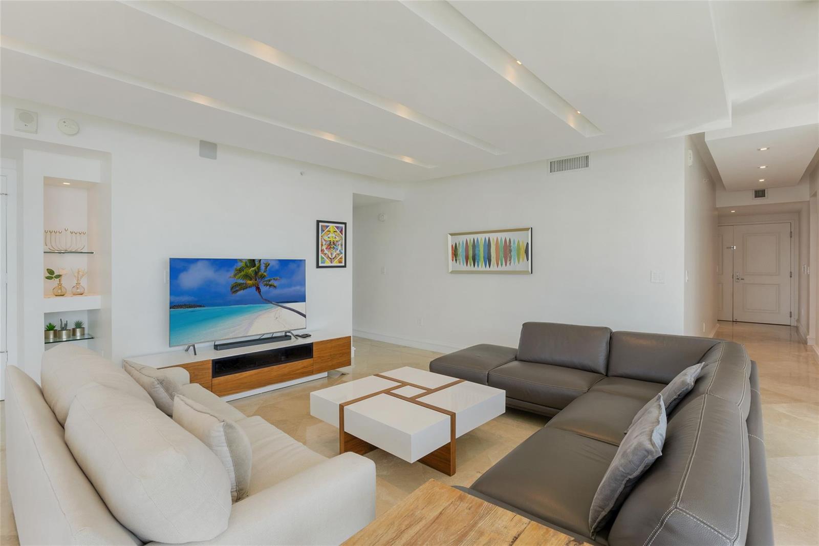 A living room features a white sofa, a grey sectional, and a modern coffee table — 3101 S Ocean Drive # 902, Hollywood FL 33019, HOLLYWOOD, FL
