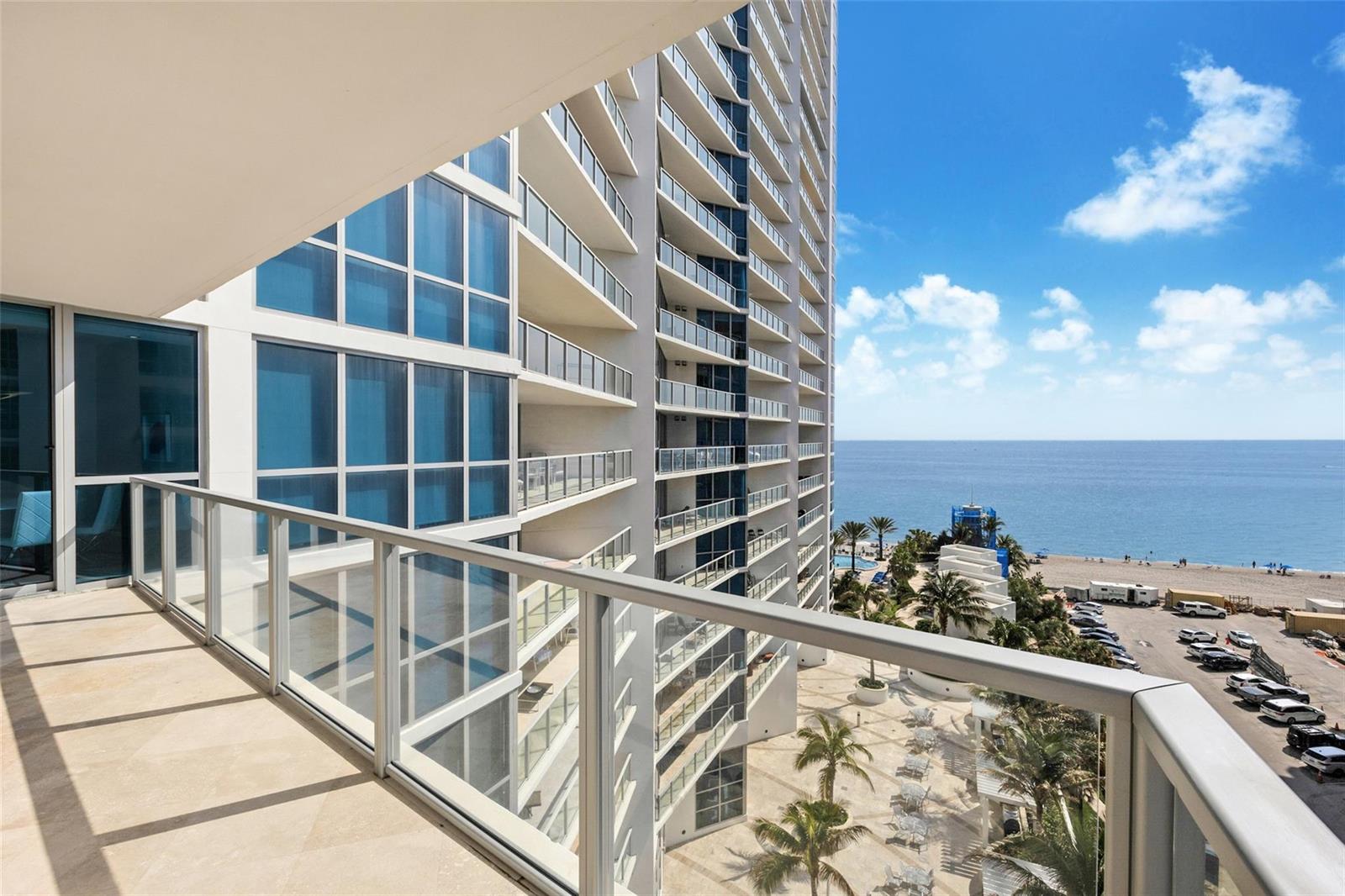 A high-rise balcony overlooks a beach, palm trees, and a parking lot — 3101 S Ocean Drive # 902, Hollywood FL 33019, HOLLYWOOD, FL