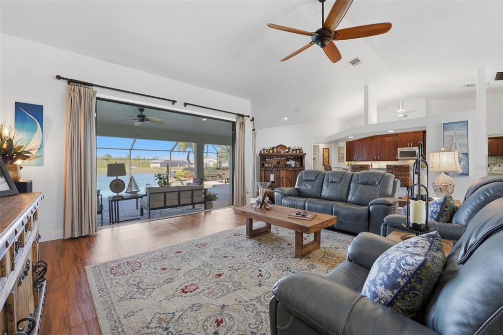 A living room with leather furniture, a wooden coffee table, and sliding doors to a patio — 15508 RUSTON CIRCLE, PORT CHARLOTTE, FL