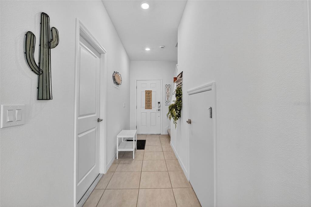 A bright entryway features tiled floors, a white door, and a small bench — 3607 MAIN HARBOR DRIVE, KISSIMMEE, FL