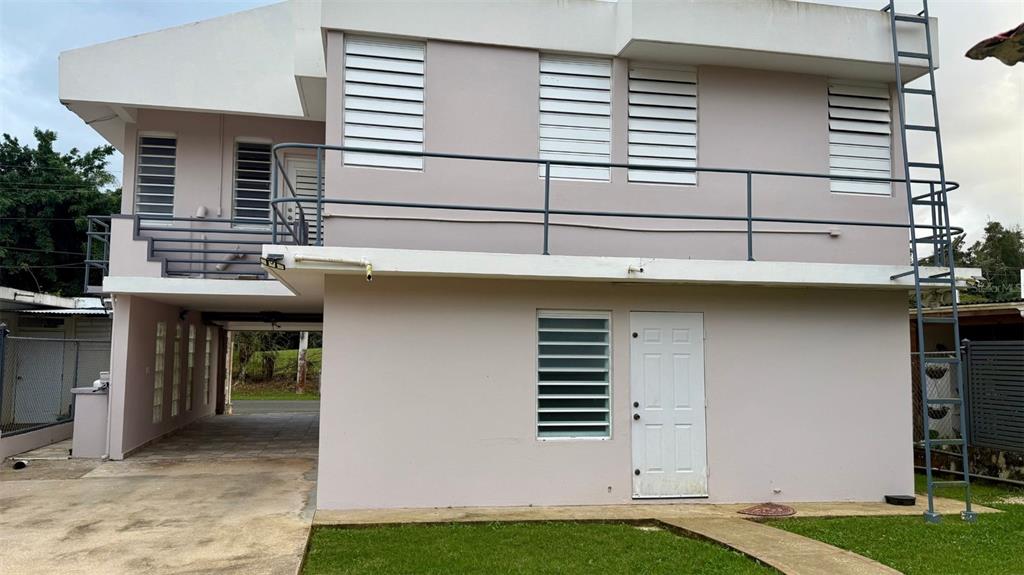 The exterior of a two-story house features a balcony, a metal ladder, and a carport — WD Colina de Lourdes FLORIDA AFUERA WD COLINAS DE LOURDES SECTOR LOT 4, BARCELONETA, PR