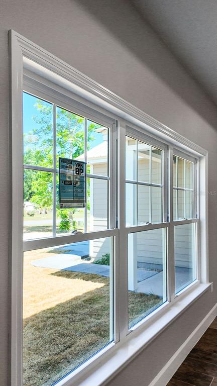 A view through a large, multi-pane white window looking out onto a grassy yard — 9100 DORIE DRIVE, TRENTON, FL