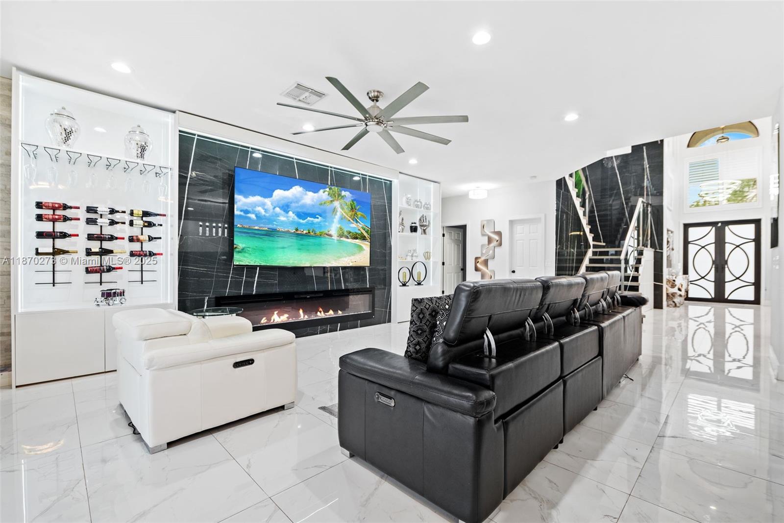 A modern living room features a black marble fireplace wall, a large television, and leather seating — 3591 SW 177th Ave, Miramar FL 33029, MIRAMAR, FL