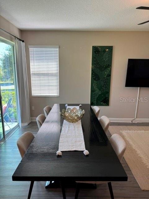 A dining room features a long black table, six chairs, and a large green wall art — 7951 RUMNEY LANE, REUNION, FL