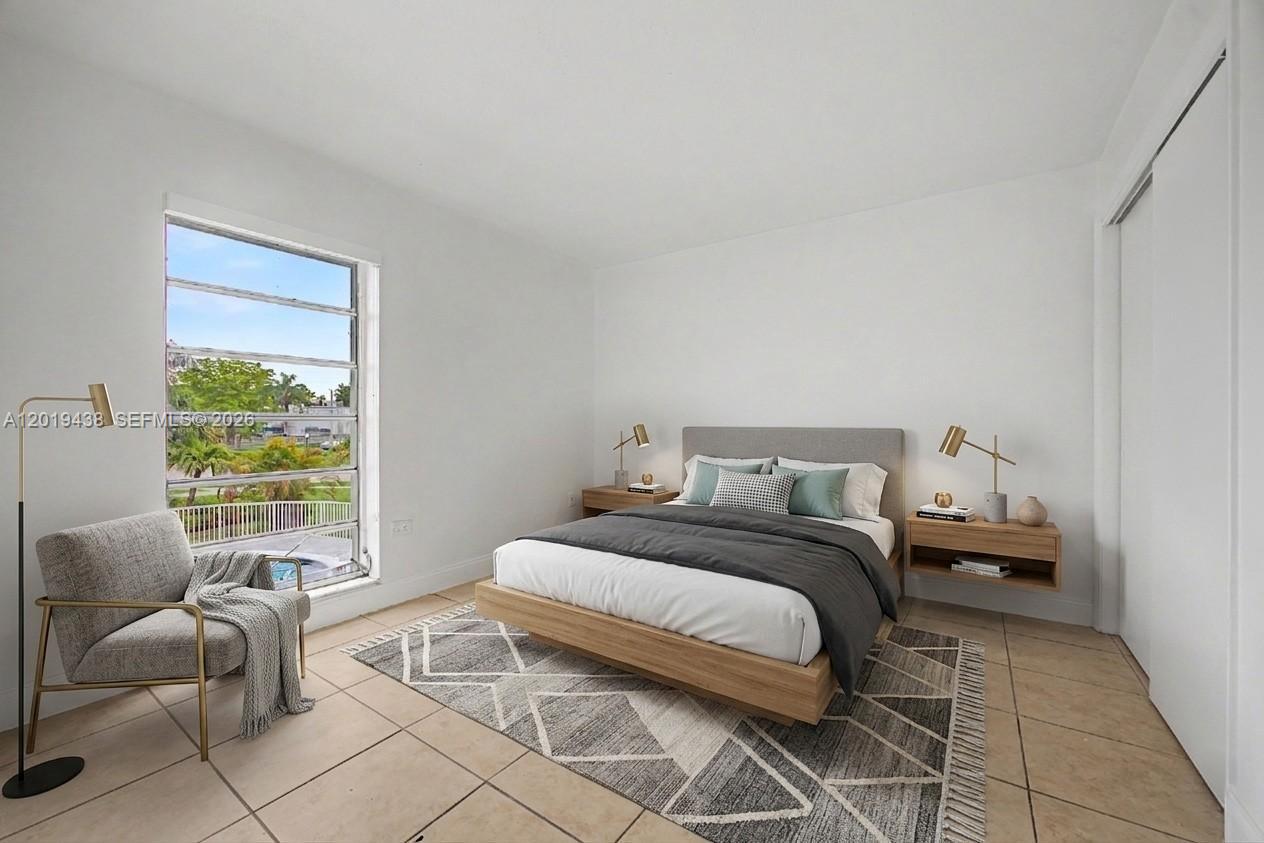 An empty room features white walls, beige tile flooring, and a sliding glass door to a balcony — 7256 SW 94th Pl # A8, Miami FL 33173, MIAMI, FL