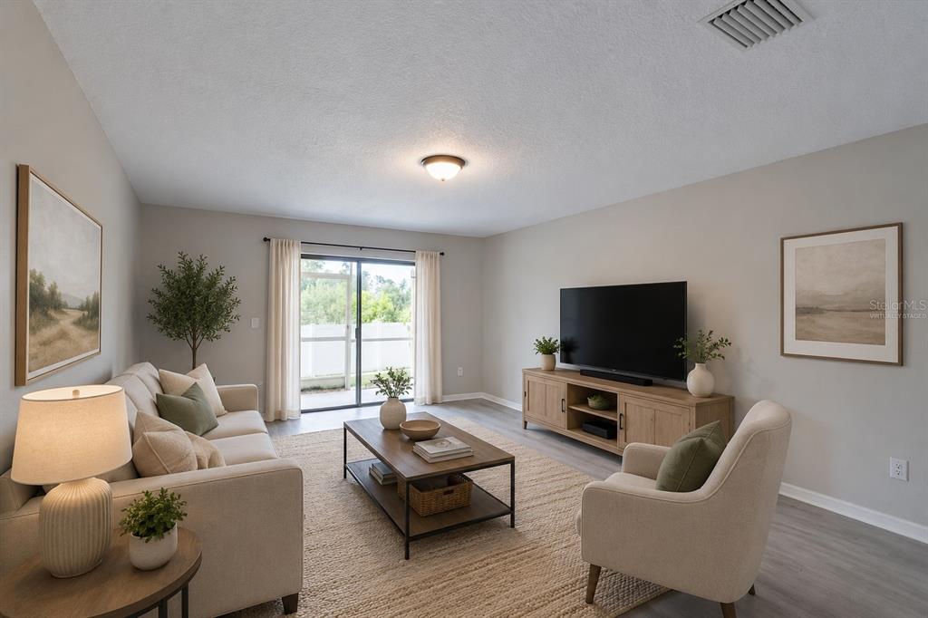 A living room features a beige sofa, armchair, coffee table, and television on a console — 10956 BRICKSIDE COURT, RIVERVIEW, FL
