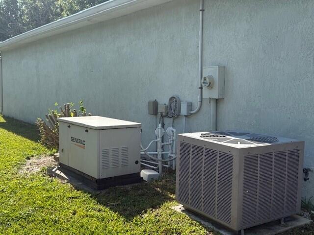 An exterior view of a house wall featuring a standby generator and an HVAC unit — 6715 Mar Pacifico, Fort Pierce FL 34951, FORT PIERCE, FL