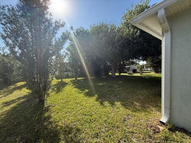 A grassy yard with trees sits beside the side wall of a house — 6715 Mar Pacifico, Fort Pierce FL 34951, FORT PIERCE, FL