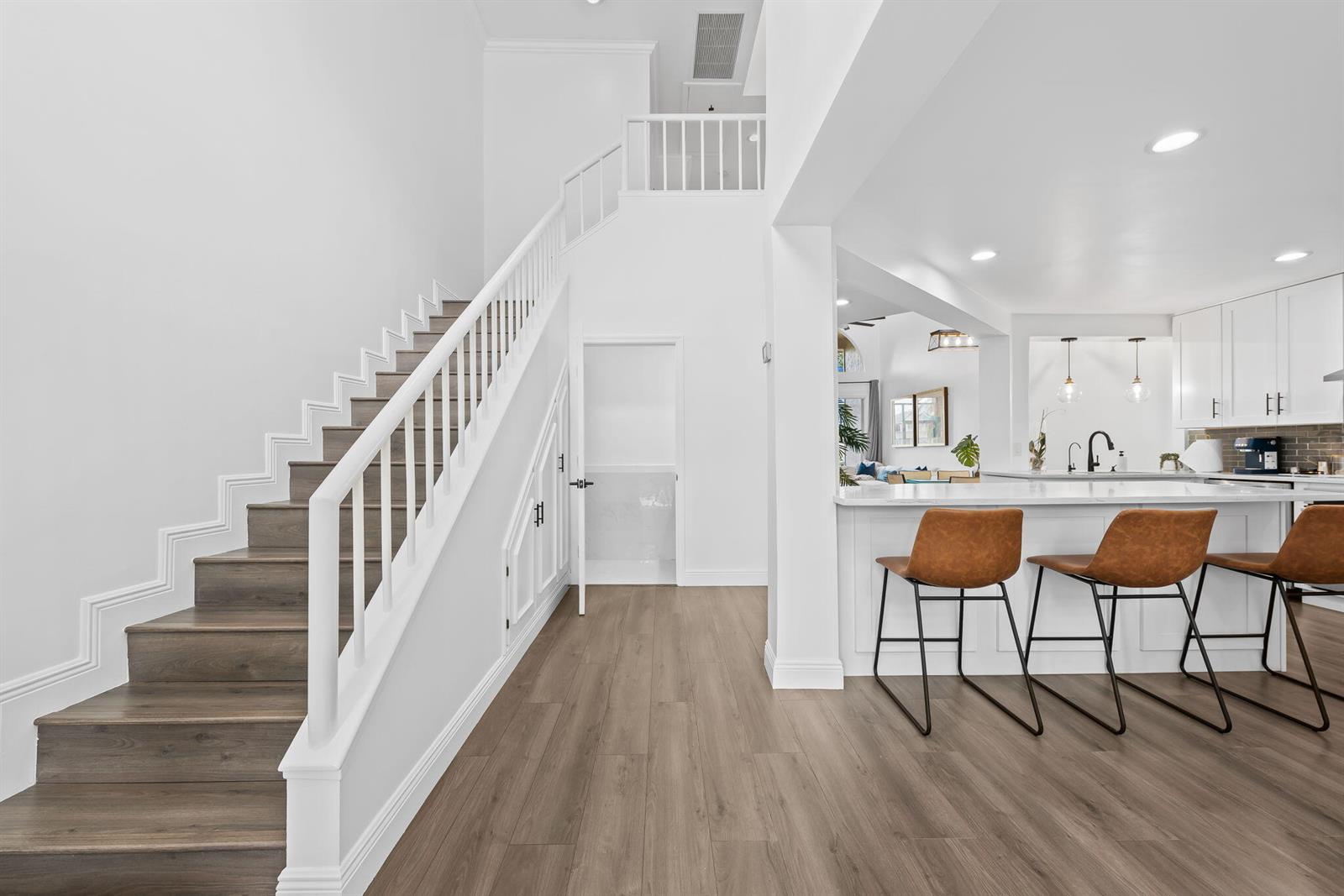 A staircase with white railings leads to a landing next to a modern kitchen — 9226 Boca Gardens Parkway, Boca Raton FL 33496, BOCA RATON, FL