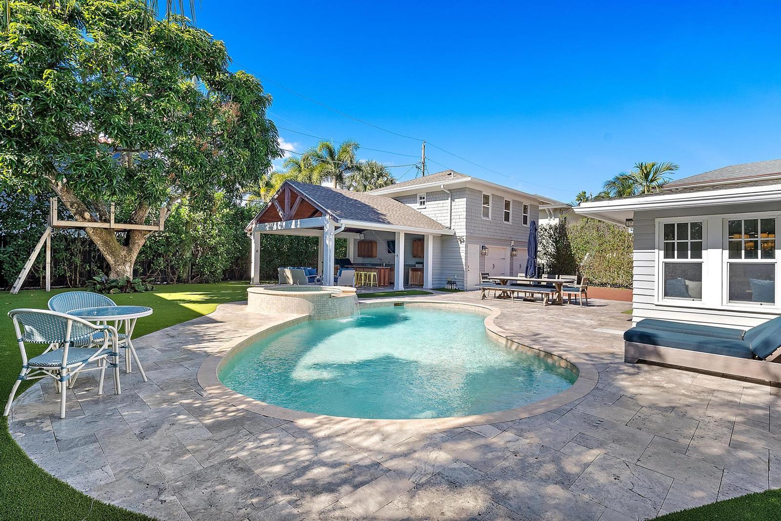 A backyard features a swimming pool, a hot tub, a covered patio, and a lawn — 3109 Washington Road, West Palm Beach FL 33405, WEST PALM BEACH, FL