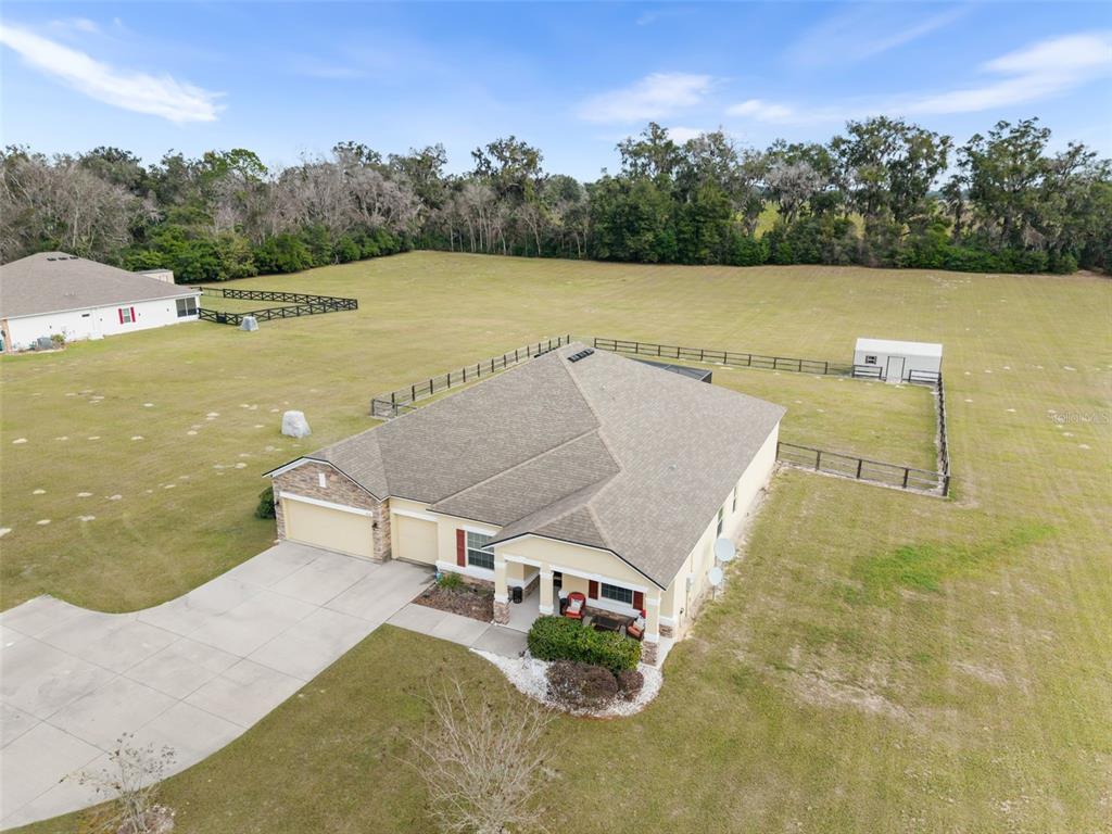 An aerial view shows a single-story house with a garage and fenced yard — 5615 SW 215TH TERRACE, NEWBERRY, FL
