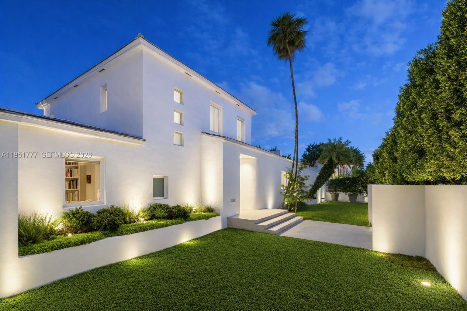 A curved staircase with light-colored treads and a metal railing stands in a white hallway — 3325 Pine Tree Dr, Miami Beach FL 33140, MIAMI BEACH, FL