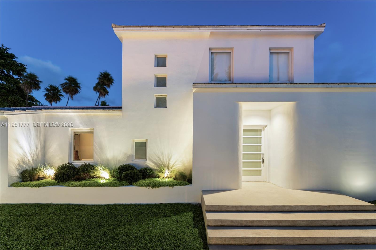 A modern white two-story house features a recessed entryway, square windows, and landscaped front garden — 3325 Pine Tree Dr, Miami Beach FL 33140, MIAMI BEACH, FL