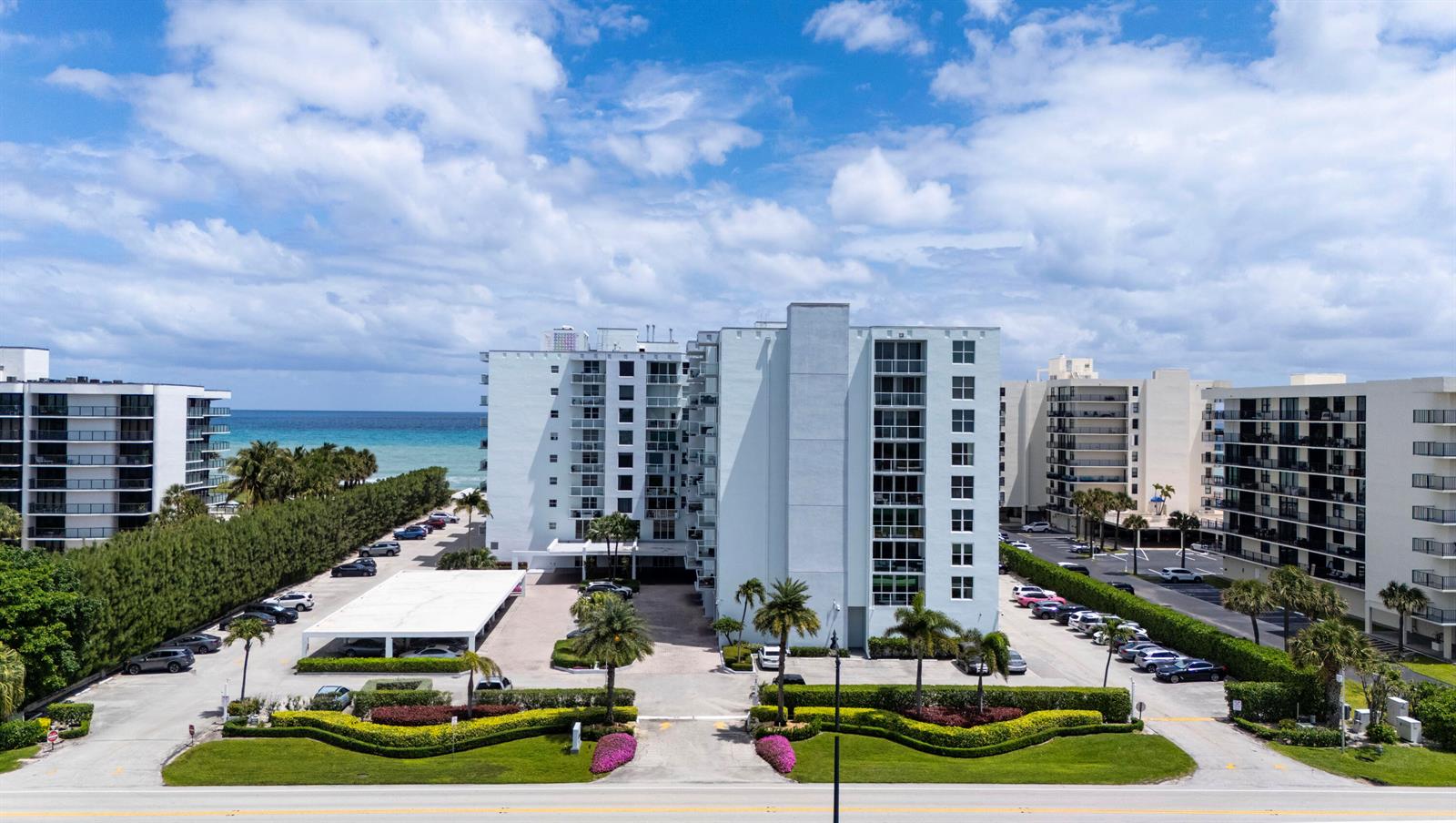 An aerial view shows several beachfront apartment buildings with swimming pools along a sandy shore — 3450 S Ocean Boulevard # 316, Palm Beach FL 33480, PALM BEACH, FL