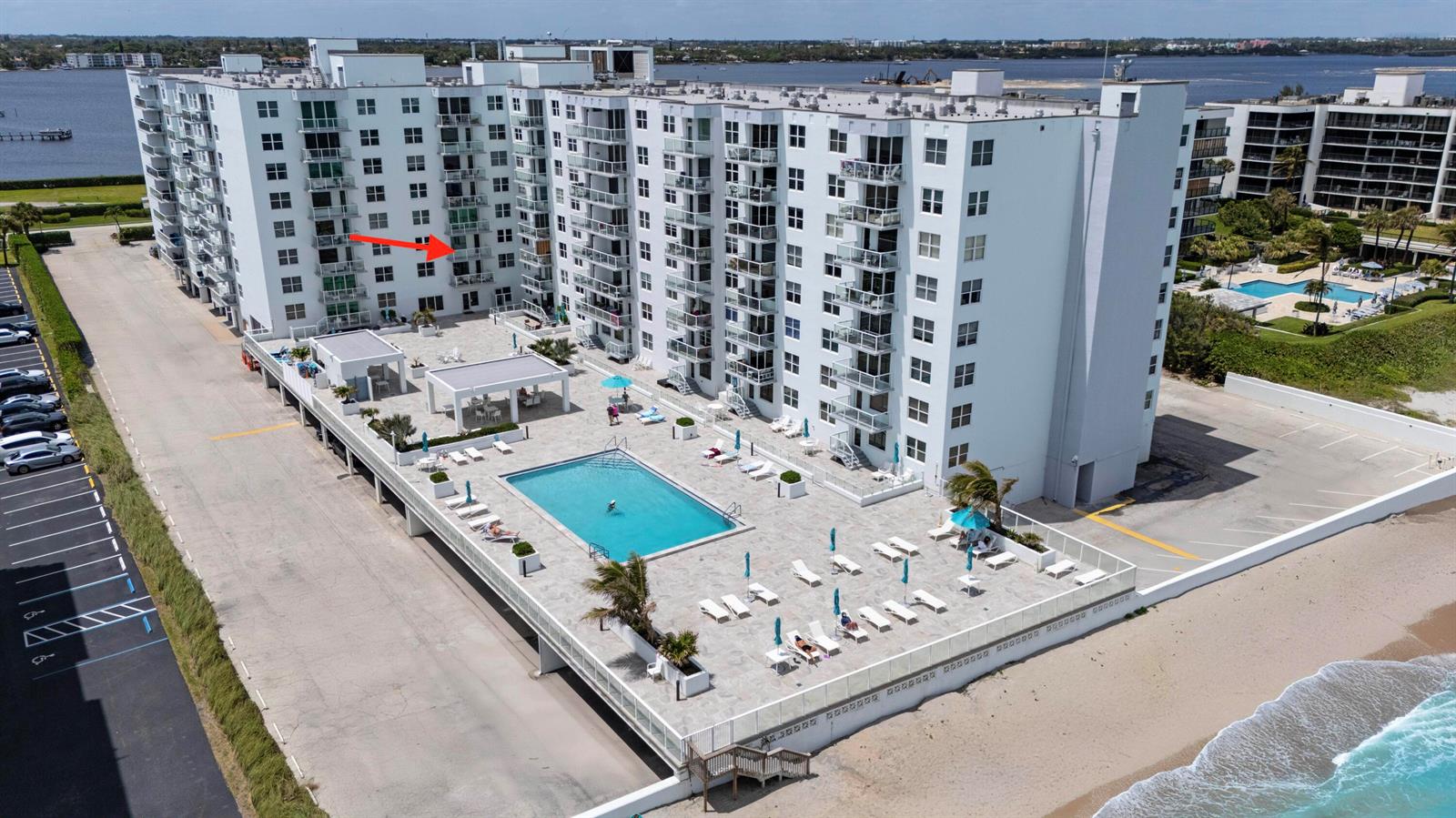 An aerial view shows a swimming pool on a patio next to a tall building — 3450 S Ocean Boulevard # 316, Palm Beach FL 33480, PALM BEACH, FL