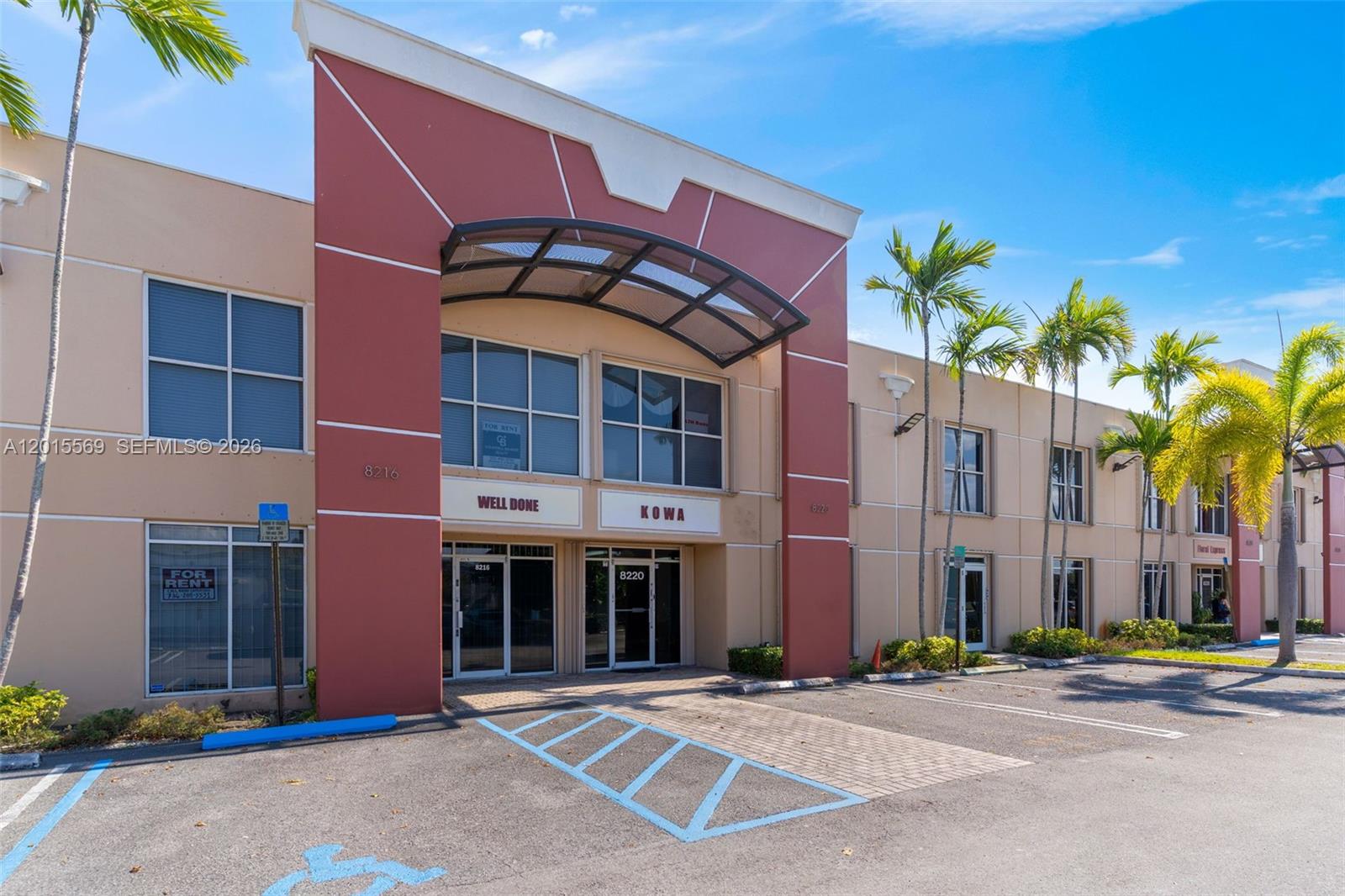 A two-story commercial building features a red facade, glass windows, and a paved parking lot — 8216 NW 30th Ter, Doral FL 33122, DORAL, FL