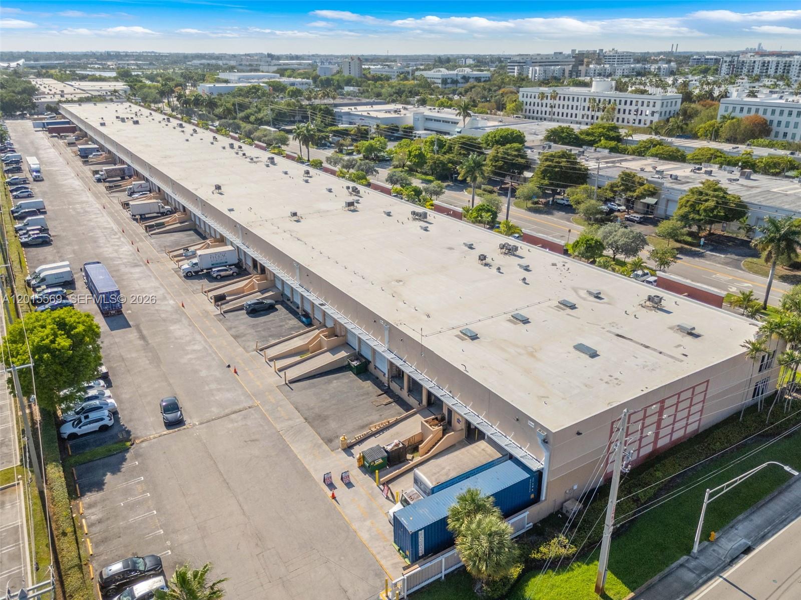 An aerial view shows a long industrial warehouse building with multiple loading docks and parking — 8216 NW 30th Ter, Doral FL 33122, DORAL, FL