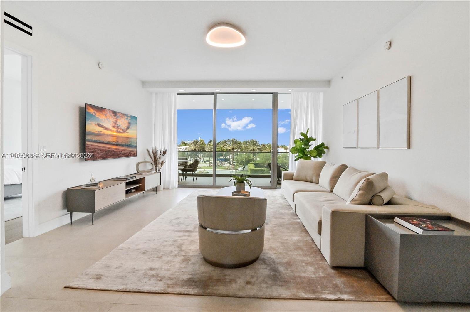 A modern living room features a beige sofa, a central armchair, and a balcony view — 10203 Collins Ave # 305, Bal Harbour FL 33154, BAL HARBOUR, FL