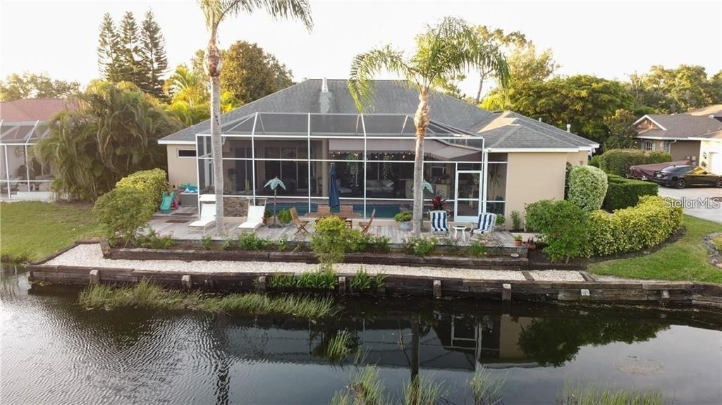 An aerial view of a house with a screened-in pool deck overlooking a canal — 5125 MAGNOLIA POND DRIVE, SARASOTA, FL