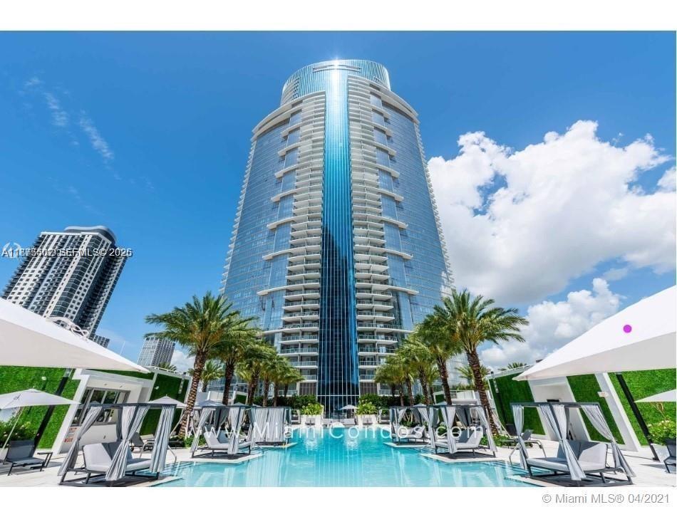 A tall glass skyscraper rises behind a swimming pool with lounge chairs and palm trees — 851 NE 1st Ave # 1203, Miami FL 33132, MIAMI, FL