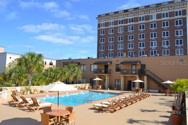 A swimming pool sits on a patio in front of a multi-story brick building — 411 1ST AVENUE N UNIT 307, ST PETERSBURG, FL