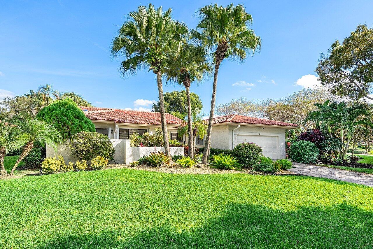 A single-story house with a red tile roof, a white garage, and tall palm trees — 18 Bristol Lane, Boynton Beach FL 33436, BOYNTON BEACH, FL