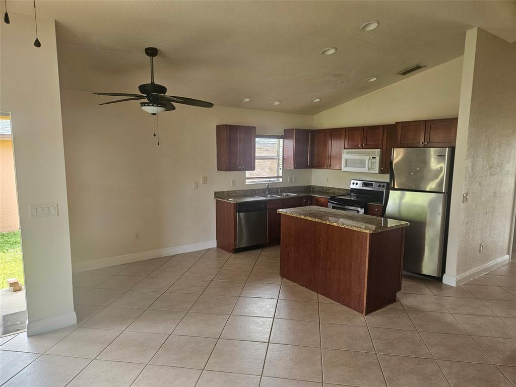 A kitchen with dark wood cabinets, stainless steel appliances, and a central island — 3221 SW SANTA BARBARA PL, CAPE CORAL, FL