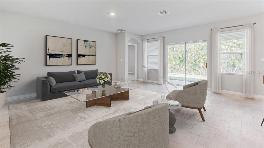 This virtually staged living room features a gray sofa, glass coffee table, and tile flooring — 16313 JUAREZ CIRCLE, PUNTA GORDA, FL
