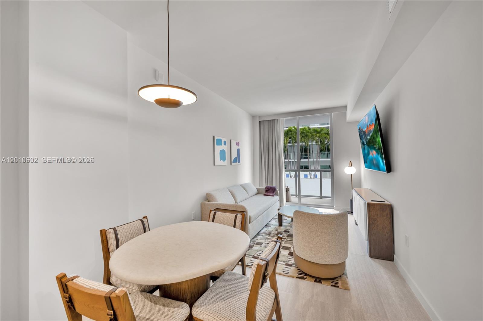 A living and dining area features a round table, sofa, armchair, and wall-mounted television — 1611 SW 2nd Ave # 414, Miami FL 33129, MIAMI, FL