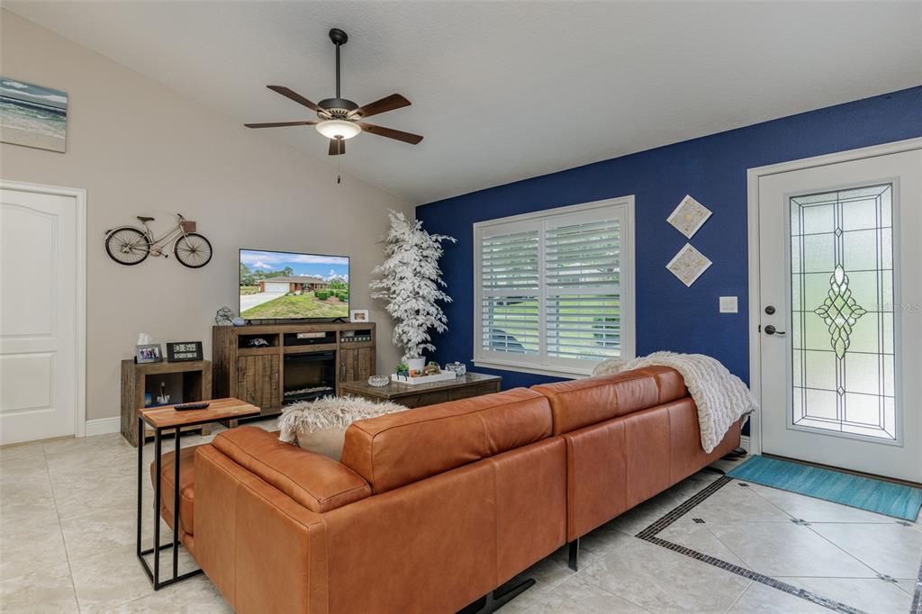 A living room features a brown leather sectional, a blue accent wall, and a ceiling fan — 1763 W MCNEAL DRIVE, DUNNELLON, FL