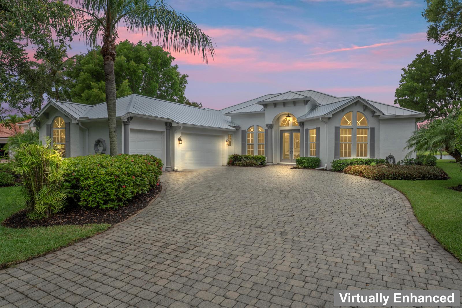 A single-story house with a metal roof, white stucco exterior, and a paved circular driveway — 918 SW Blue Stem Way, Stuart FL 34997, STUART, FL