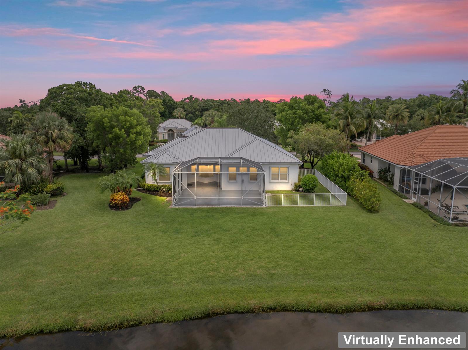 An aerial view of a house with a metal roof, screened lanai, and large backyard — 918 SW Blue Stem Way, Stuart FL 34997, STUART, FL