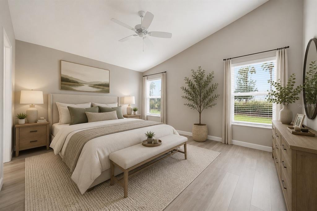 A bedroom features a king bed, a bench, a dresser, and a ceiling fan — 302 ZINGALE LANE, THE VILLAGES, FL