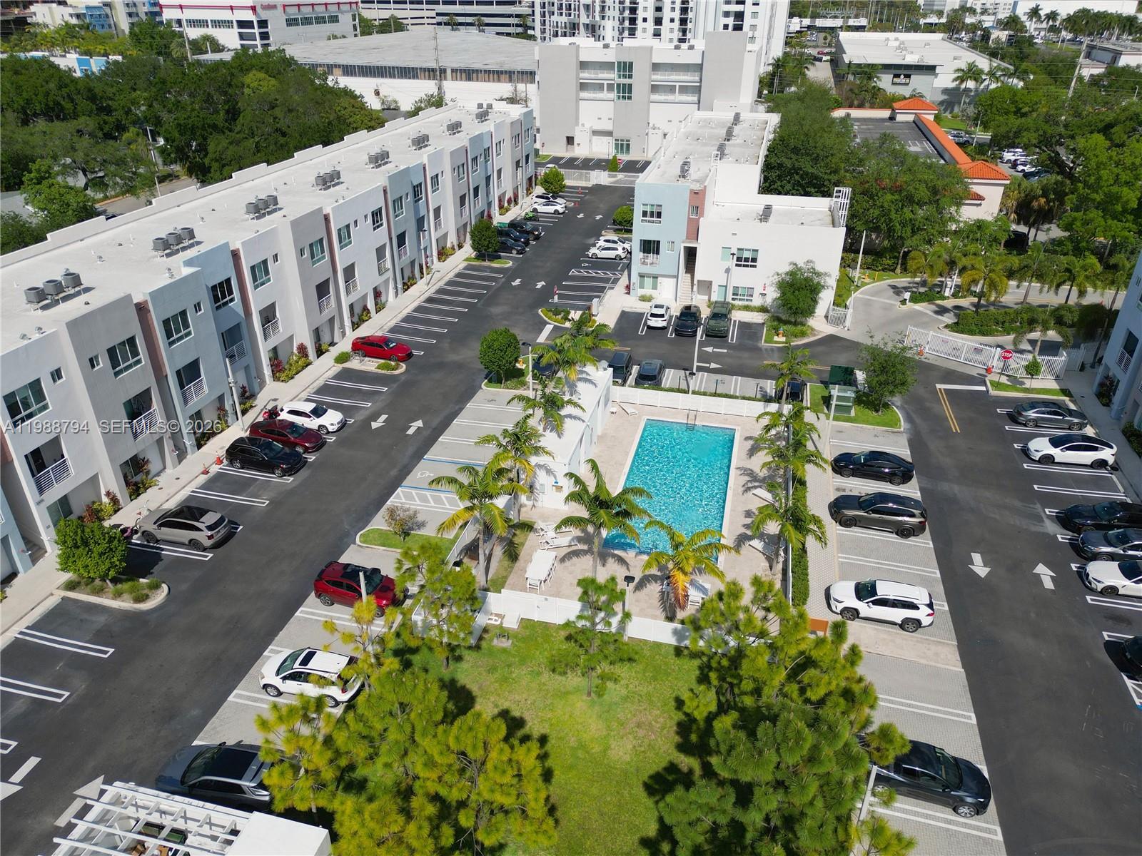 An aerial view shows a multi-story apartment complex with a central swimming pool and parking — 2505 NE 193rd St # 4208, Miami FL 33180, MIAMI, FL