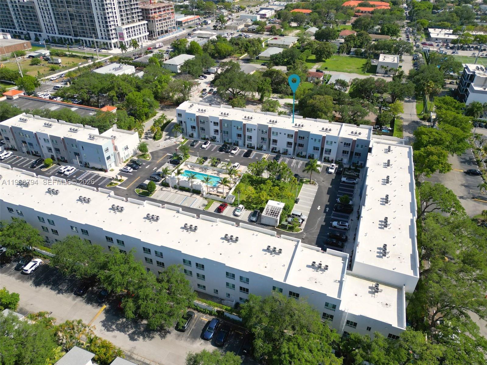An aerial view shows a multi-story apartment complex with a central pool and parking lot — 2505 NE 193rd St # 4208, Miami FL 33180, MIAMI, FL