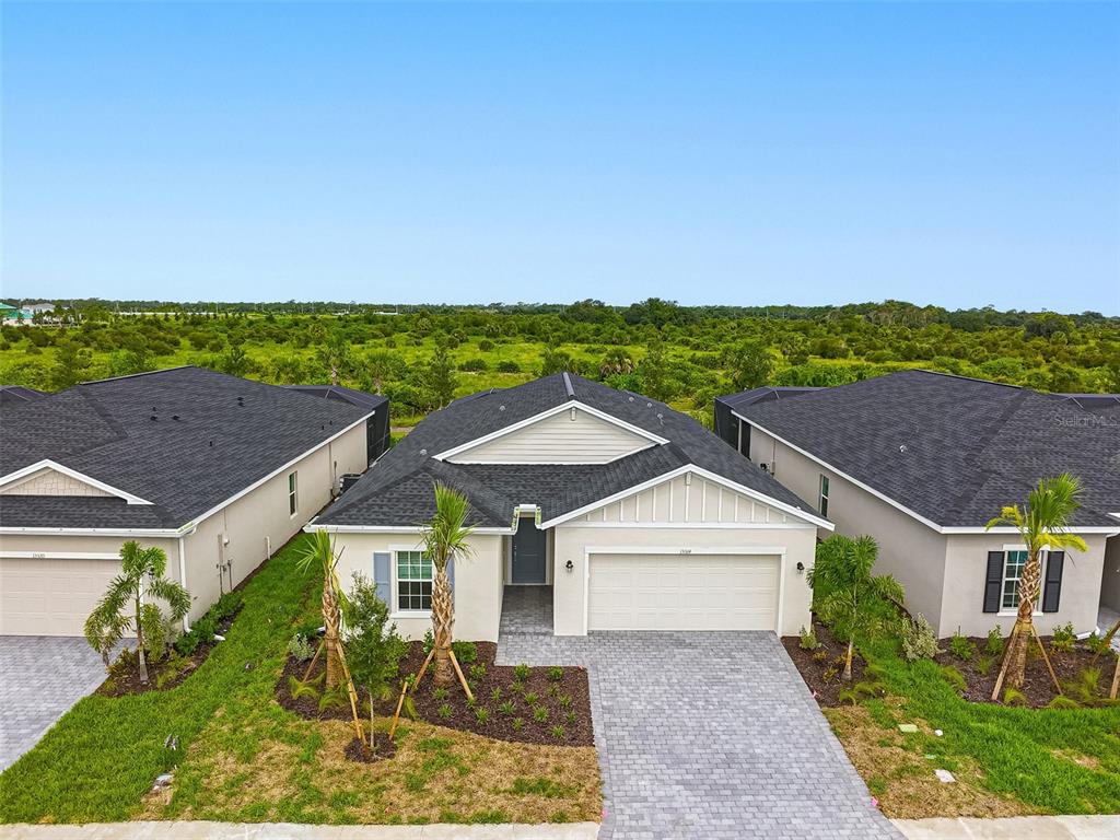 An aerial view shows the front exterior of a single-story house with a paved driveway — 13314 GRASSMERE COURT, PUNTA GORDA, FL