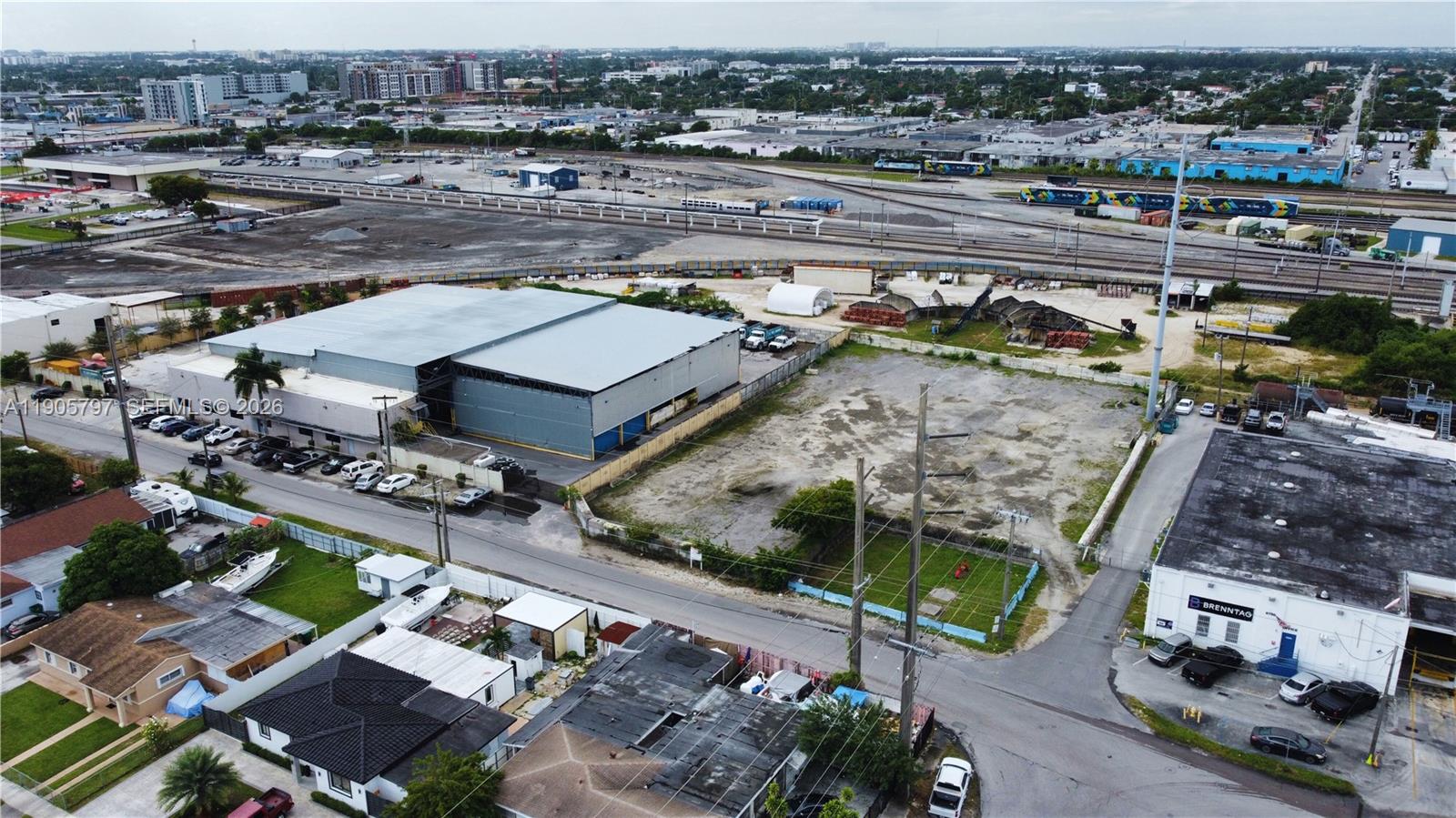 An aerial view shows a large warehouse, a vacant lot, and nearby industrial rail tracks — 8650 NW 36 Ave, Miami FL 33147, MIAMI, FL